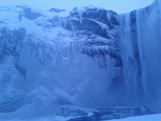 Halb zugefrorener Wasserfall Skogafoss