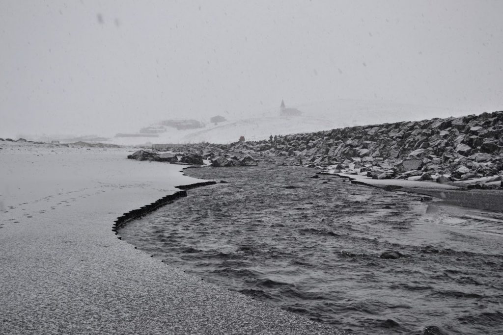 Schwarzer Strand in Island bei Schneefall