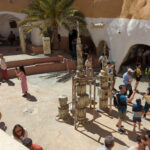 Innenhof Hotel Sidi Idriss mit Ausstellungsstücken und Menschen